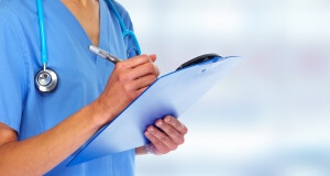 Doctor writing on a clipboard.